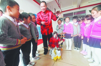 ②日前,在连城县实验幼儿园,连城木偶戏大师李明卿为孩子们表演提线